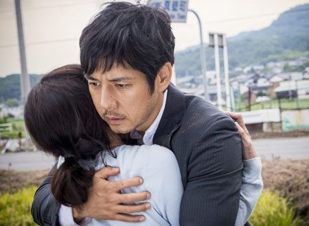 妻・康子をかばうように抱きしめる高倉(西島秀俊)