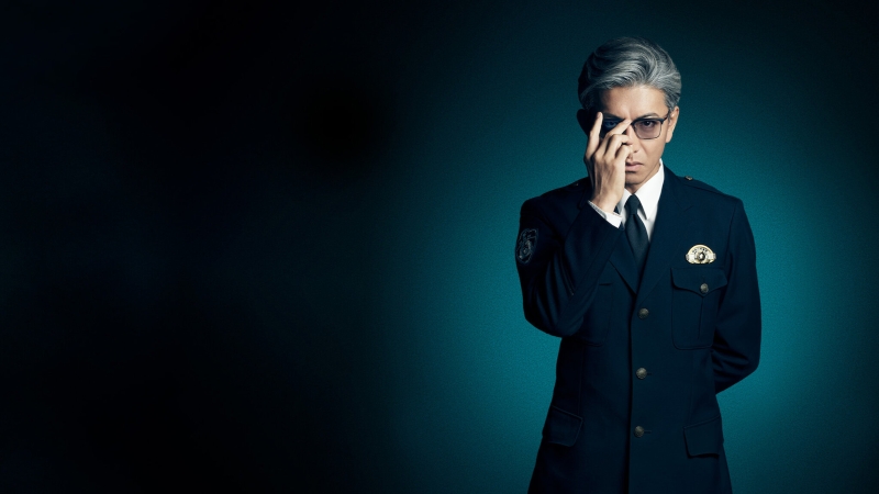 制服姿で眼鏡に手を添え、鋭い視線を向ける風間公親(木村拓哉)